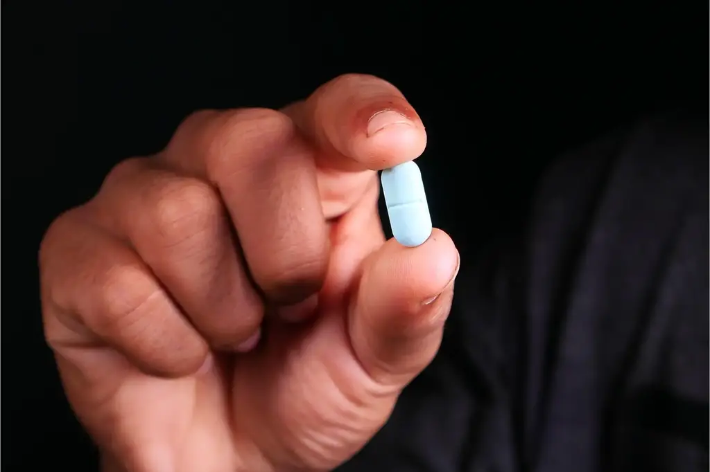 A Man Holds a Pill Medicine