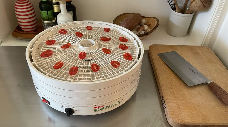 Image of the required equipment (knife cutting board paper towels baking sheet dehydrator oven) neatly arranged.